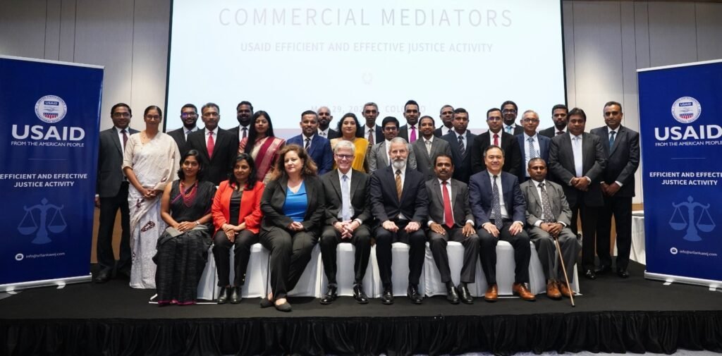 In Colombo, on Wednesday, May 29, 2024, a group of newly accredited commercial mediators initiate a mock mediation demonstration with a handshake during a ceremony. This event celebrates their successful training, supported by USAID’s Efficient and Effective Justice activity.